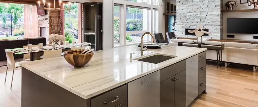 Luxury open-concept kitchen with waterfall island, quartz countertops, and modern living space