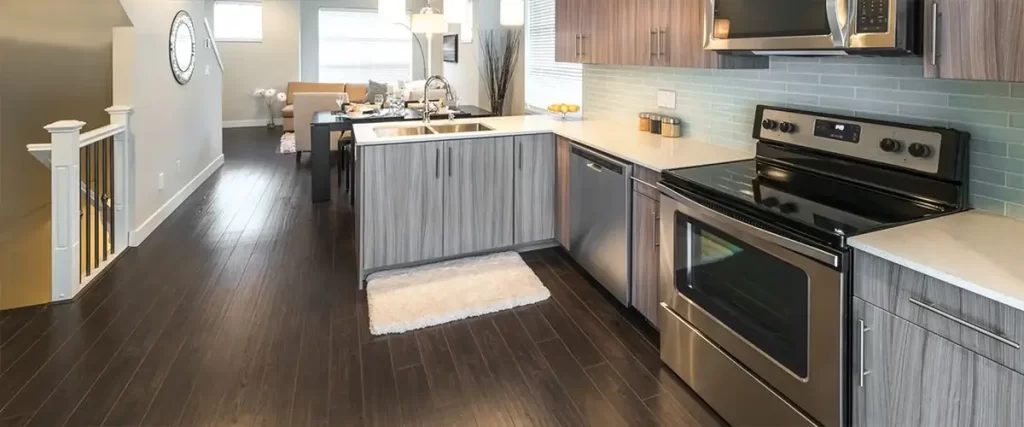 Modern kitchen remodel with wood grain cabinets, stainless steel appliances, and island sink