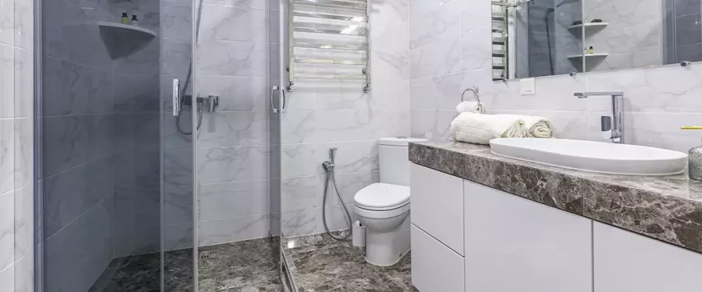 Modern marble bathroom remodel with glass shower, floating vanity, and luxury tile flooring