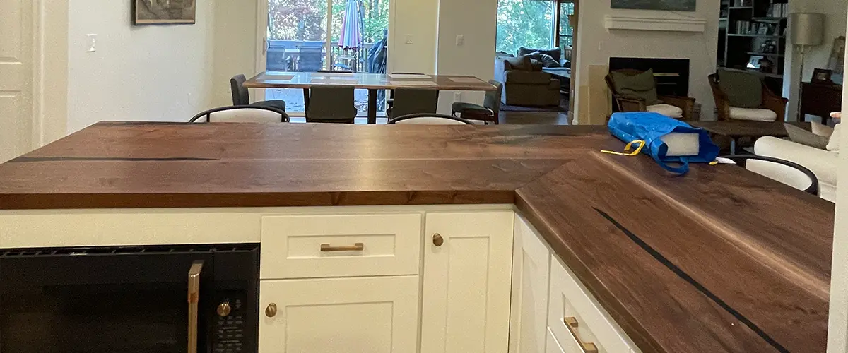 Open concept kitchen remodel with butcher block countertop and modern dining area