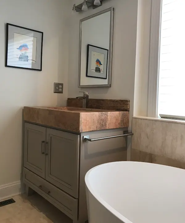 Bathroom remodeling with custom vanity, stone sink, freestanding tub, and modern fixtures