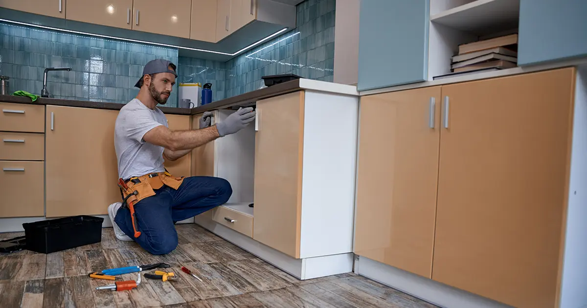 Contractor installing kitchen cabinets during a professional kitchen remodeling project
