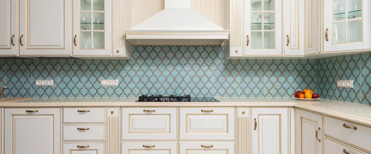 Custom kitchen remodeling with white cabinets, decorative tile backsplash, and built-in range hood