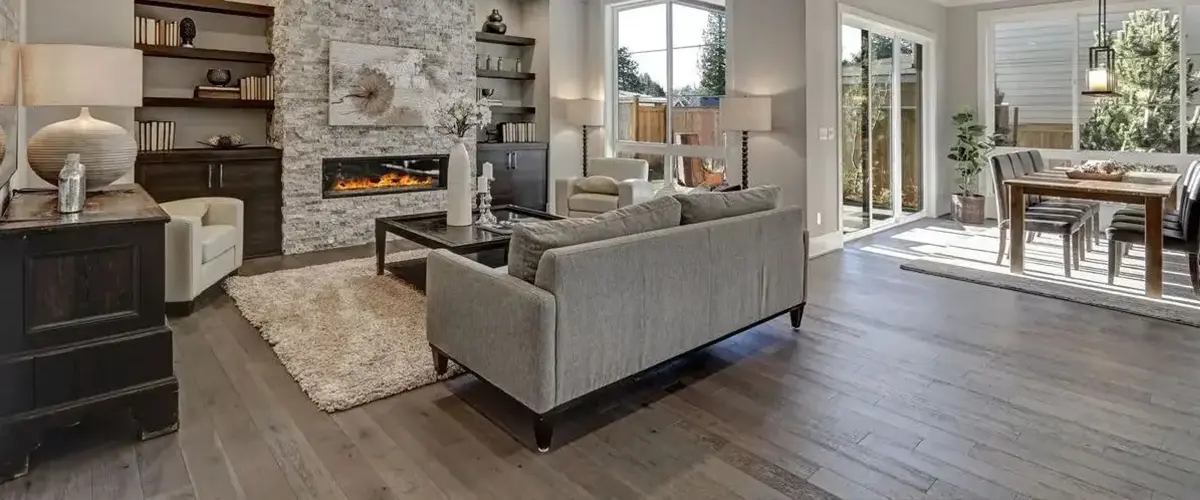 Open-concept home addition with living room, fireplace, dining area, and abundant natural light