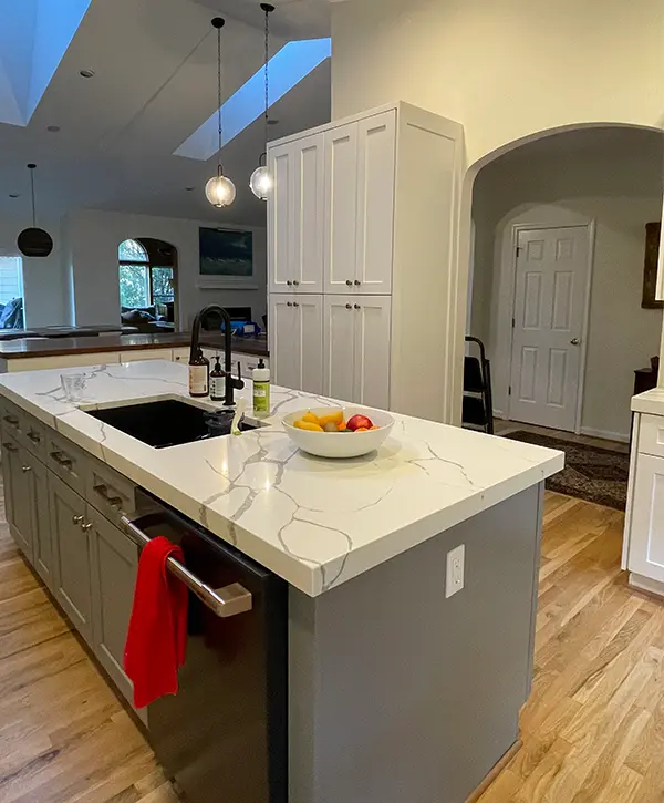 Open-concept kitchen remodeling with quartz island, custom cabinetry, skylights, and modern finishes